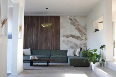a living room with a green couch and a table at Vakantiewoning voizin tot 6 personen in Haaltert