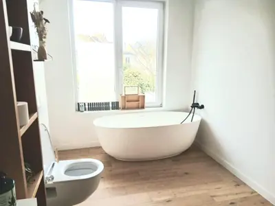 a white bath tub in a bathroom with a window at Mi casa es su casa in Ghent