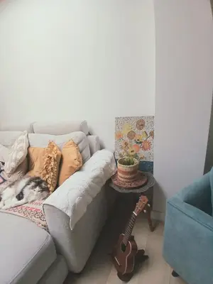 a living room with a couch and a guitar at Mi casa es su casa in Ghent