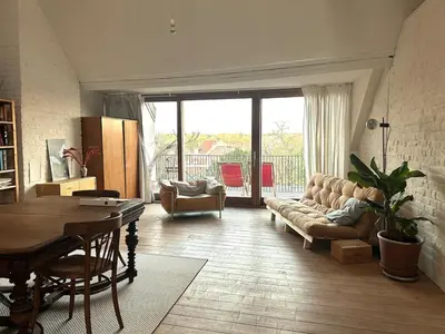 a living room with a couch and a table at Penthouse studio in a family house in Brussels