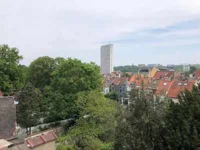 a view of a city with a tall building in the background at Penthouse studio in a family house in Brussels