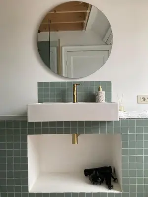 a bathroom with a sink and a mirror at Penthouse studio in a family house in Brussels
