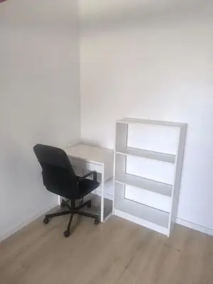 a black chair sitting next to a desk and a shelf at Nice apartment close to Zaventem airport in Kampenhout