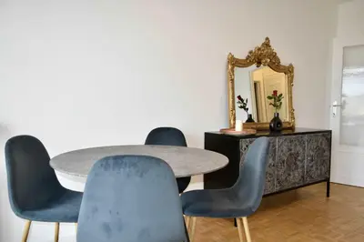 a dining room with a table and chairs and a mirror at Avenue Louise skyline view in Brussels