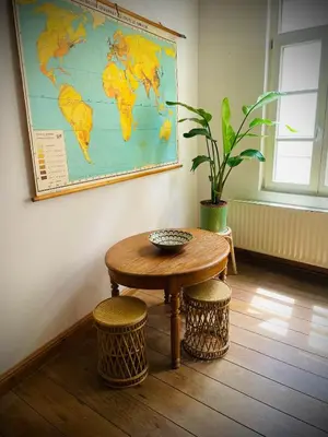 a table and stools in a room with a map on the wall at Alcazar in Mechelen