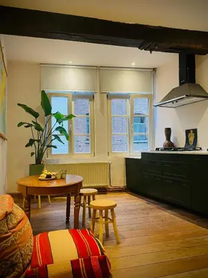 a kitchen with a table and chairs in a room at Alcazar in Mechelen