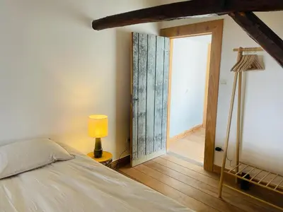 a bedroom with a bed and a lamp and a door at Alcazar in Mechelen