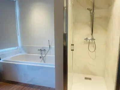 a bathroom with a tub and a shower with a shower at Alcazar in Mechelen