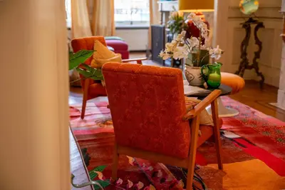 a living room with a table and a chair at Papillon Boutique Villa Centre Antwerp in Antwerp