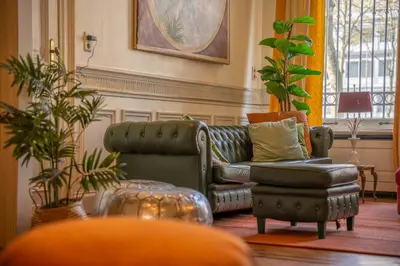 a living room with a leather couch and a chair at Papillon Boutique Villa Centre Antwerp in Antwerp