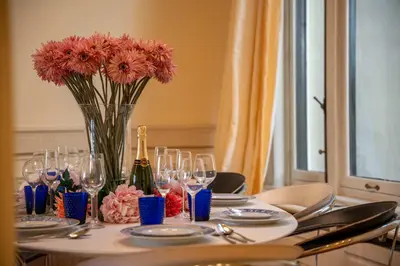 a table with a vase of flowers and wine glasses at Papillon Boutique Villa Centre Antwerp in Antwerp