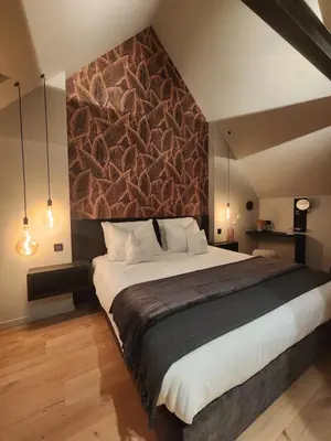 a bedroom with a large bed with a wall at Obobonne in Geraardsbergen