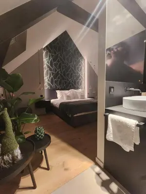 a bathroom with a bed and a sink in a room at Obobonne in Geraardsbergen