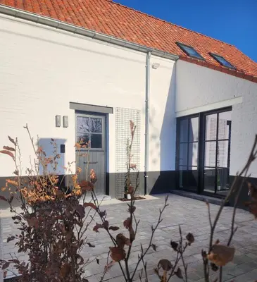 a white building with a door and a red roof at Obobonne in Geraardsbergen