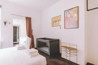 a white room with a bed and a television at Central Ghent Apartment for 3 Guests in Ghent