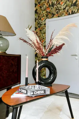 a table with a vase with a book and two candles at Central Ghent Apartment for 3 Guests in Ghent