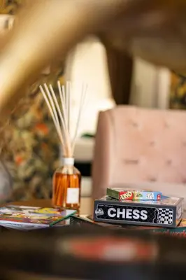 a table with a book and a bottle of chess on it at Central Ghent Apartment for 3 Guests in Ghent