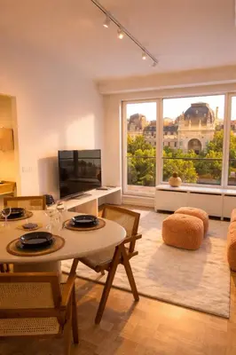 a living room with a table and chairs and a large window at Luxury penthouse in Antwerp in Antwerp