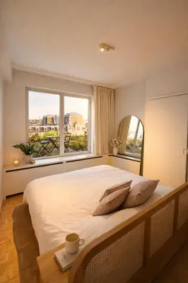 a bedroom with a large bed and two windows at Luxury penthouse in Antwerp in Antwerp