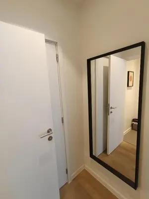 a mirror on a wall next to a door at Studio charmoso in Brussels