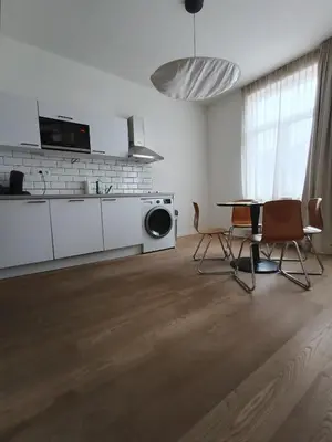a living room with a kitchen and a table and chairs at Studio charmoso in Brussels