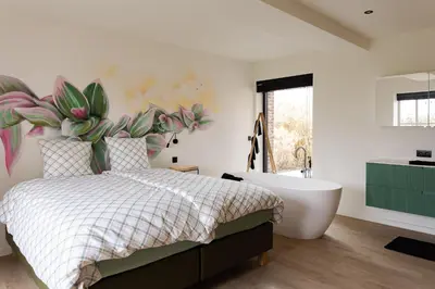 a bedroom with a large bed and a bath tub at Vakantiehoeve Breathe Nature in Lochristi