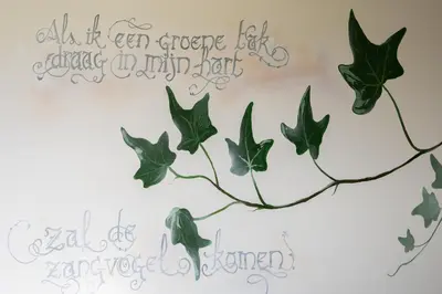 a painting of leaves on a wall at Vakantiehoeve Breathe Nature in Lochristi