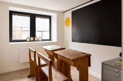 a classroom with a table and chairs and a blackboard at Vakantiehoeve Breathe Nature in Lochristi