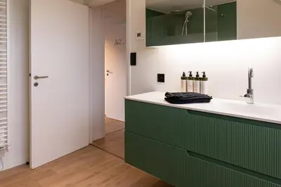 a kitchen with a green and white counter and a sink at Vakantiehoeve Breathe Nature in Lochristi