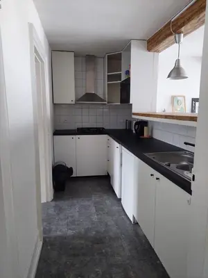 a small kitchen with white cabinets and a sink at Typical flat Grand Place in Brussels