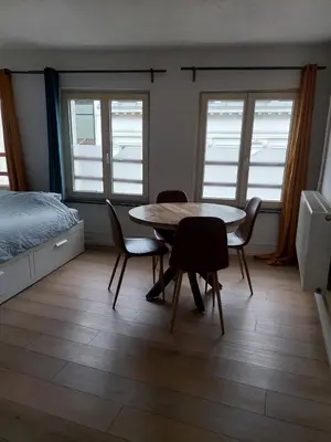 a room with a table and chairs and a bed at Typical flat Grand Place in Brussels