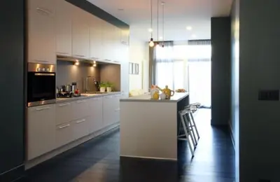 a large kitchen with white cabinets and a counter top at Parc Brussels Apartment in Brussels