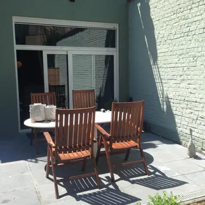 a patio with three chairs and a table and a window at Parc Brussels Apartment in Brussels