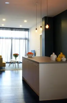 a kitchen with a counter top and a living room at Parc Brussels Apartment in Brussels