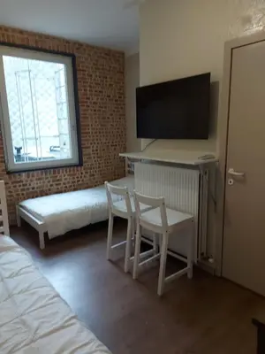a bedroom with a bed and a desk with a tv at Deurne in Antwerp