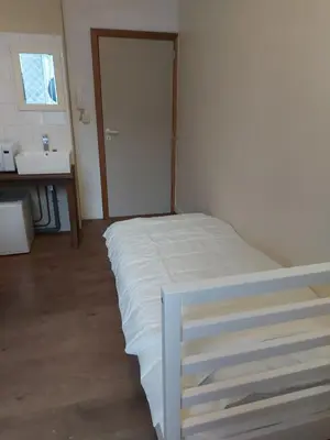 a bedroom with a white bed and a sink at Deurne in Antwerp