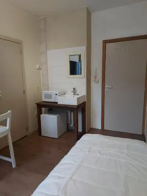 a bathroom with a sink and a bed in a room at Deurne in Antwerp