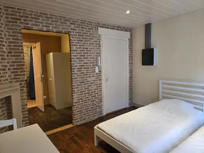 a bedroom with a bed and a brick wall at Schijnpoort in Antwerp