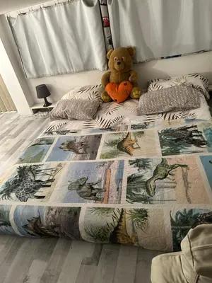 a teddy bear sitting on a bed in a bedroom at Belle chambre à sous pente au cœur de Bruxelles in Brussels