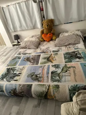 a teddy bear sitting on a bed in a bedroom at Belle chambre à sous pente au cœur de Bruxelles in Brussels