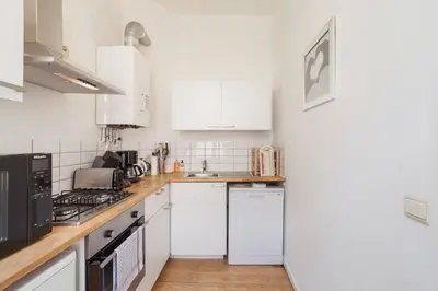 a kitchen with white cabinets and a counter top at 1 Bedroom W Kitchen and Bathroom In Trendy St Gilles in Brussels