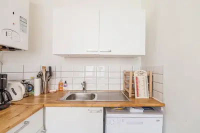 a kitchen with white cabinets and a sink at 1 Bedroom W Kitchen and Bathroom In Trendy St Gilles in Brussels
