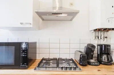 a kitchen with a stove and a microwave at 1 Bedroom W Kitchen and Bathroom In Trendy St Gilles in Brussels