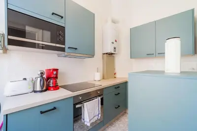 a kitchen with blue cabinets and a red appliance at 1 Bedroom W Kitchen and Bathroom In Trendy St Gilles in Brussels