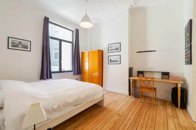 a bedroom with a bed and a desk and a window at 1 Bedroom W Kitchen and Bathroom In Trendy St Gilles in Brussels