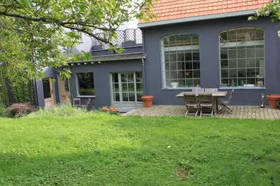 a house with a table and chairs in the yard at Furnished house BXL- for team of workers in Beersel