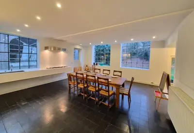 a dining room with a table and some windows at Furnished house BXL- for team of workers in Beersel