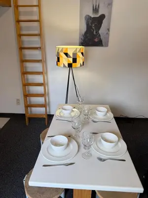 a white table with plates and glasses and a lamp at Cozy home in Zottegem in Zottegem