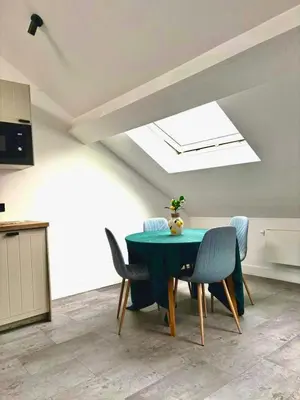 a dining room with a green table and chairs at Grand Place Bourse Prestige in Brussels