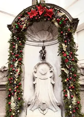 a christmas wreath on a wall with a statue at Grand Place Bourse Prestige in Brussels